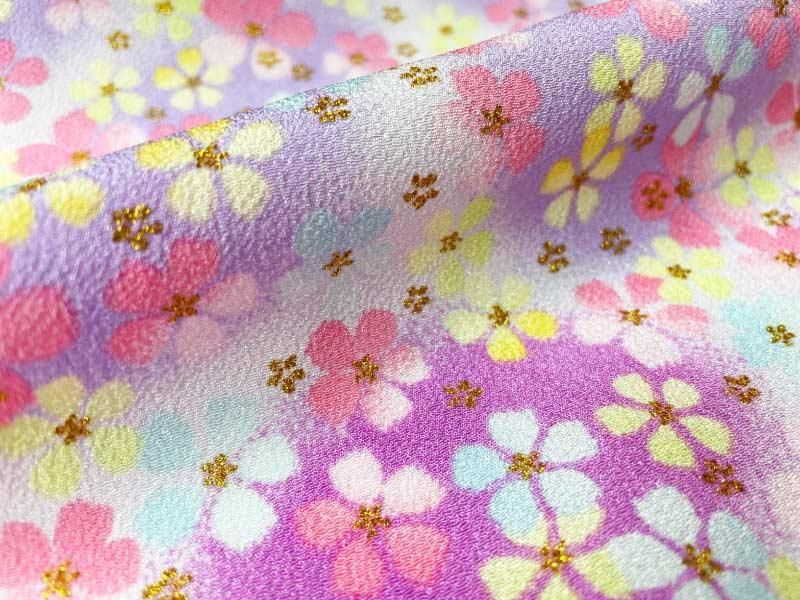 夢ふわり一越ちりめんの模様アップ画像。綿菓子のような花模様と金の小花が重なる、ゆめかわ系のぼかし生地